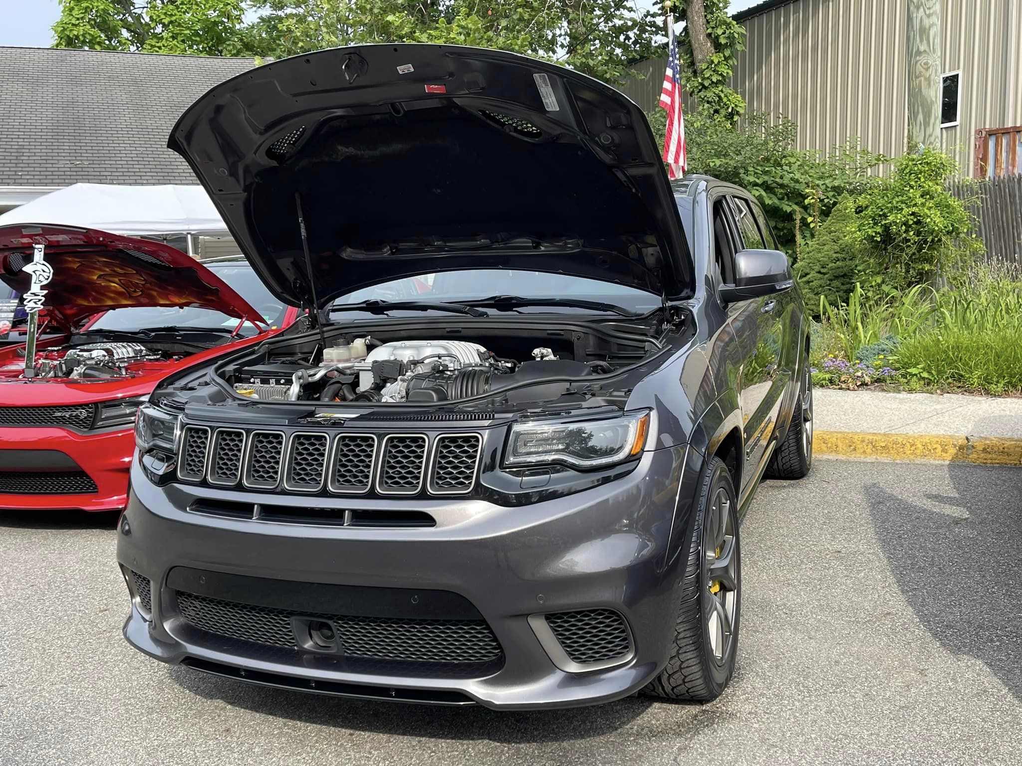 Jeep Trackhawk displayed with its hood open at a car show
